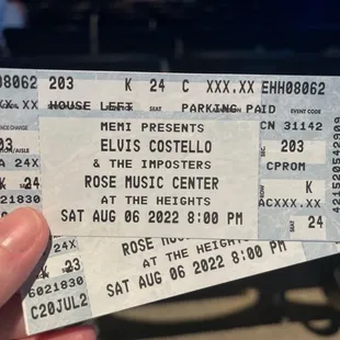 a hand holding a concert ticket