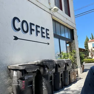 Outside. The patio furniture is next to the trash can.