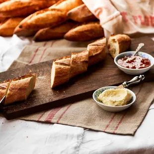 a cutting board with bread and butter