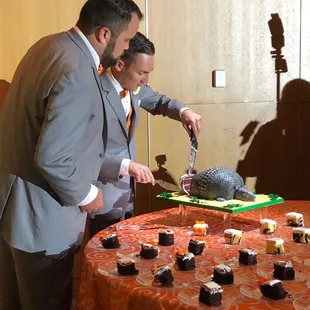 two men cutting a cake