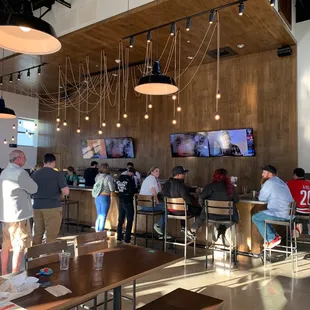 people sitting at tables and watching tvs