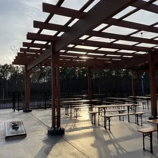 tables and benches under a pergolated roof