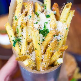 a person holding a cone of french fries