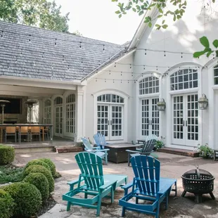 a patio with chairs and a fire pit