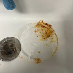 Pictures of what is supposed to be meat lasagna and a melted plastic lid due to poor delivery handling.