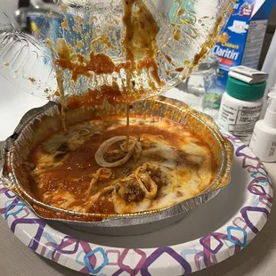 Meat lasagna with a melted plastic lid