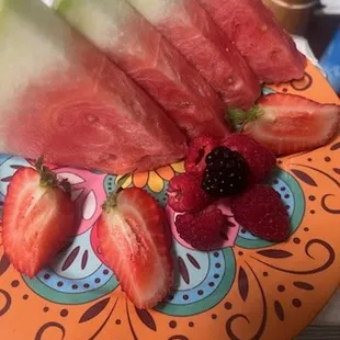 a plate of watermelon and strawberries