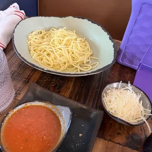 Kids spaghetti with sauce and cheese on the side