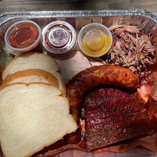 The Rosemeyer Sampler 1/2lb of Each: Brisket, Pulled Pork &amp; Ribs. One link of sausage &amp; two sides (small). Served with bread, sauce &amp; fixins