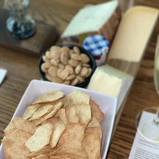 Charcuterie board featuring GF crackers, Marcona almonds, honey, tripe crème Brie, manchego, and aged Gouda