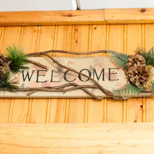 welcome sign with pine cones
