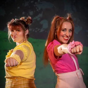 two girls in costume pointing at the camera