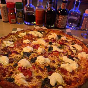 Pizza with pesto, burrata, and hot cherry peppers.