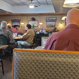 people sitting at tables in a restaurant