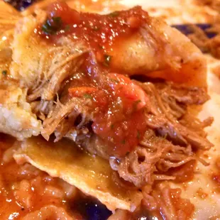 Close up all the Shredded Beef on Rosie's Beef Enchilada.