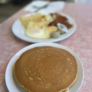 a plate of pancakes and a plate of eggs