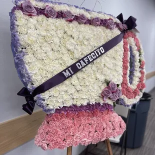 Flower display of a cup with cafecito ribbon