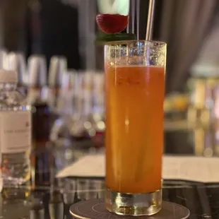 a glass of orange juice with a straw