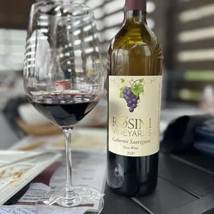 a glass of red wine and a bottle of wine