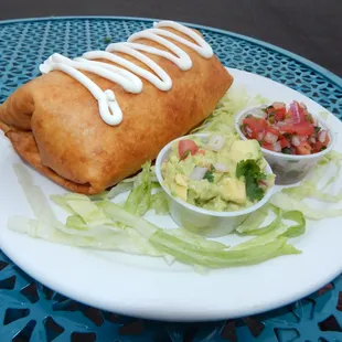 Chimichanga- Filled with Shredded Beef or Shredded Chicken, beans and cheese. Served with lettuce, sour cream, fresh salsa and guacamole.