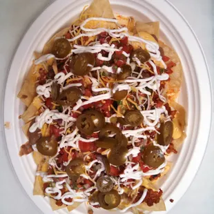 Nachos: fresh made chips topped with meat,beans,cheese sauce, shredded cheese, sour cream, fresh salsa, guacamole &amp; jalapeños.