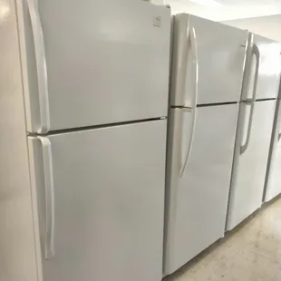 Row of refrigerator-freezers ready for sale and delivery - minus the one on the end!