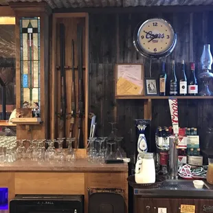a bar with wine glasses and a clock