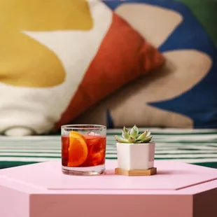 a pink table with two glasses of drink and a succulent succulent