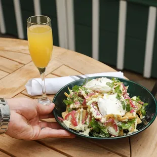 a plate of salad and a glass of orange juice