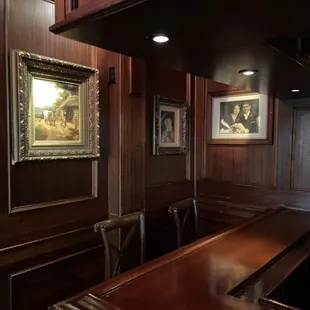 a wooden bar with a painting on the wall