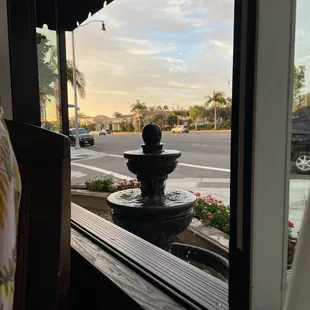 a water fountain in front of a window