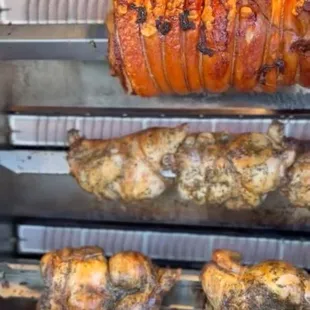 His huge rotisserie , cooking porchetta and roast chicken.