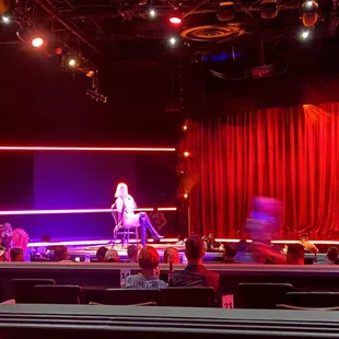 a woman standing on a stage in front of a crowd