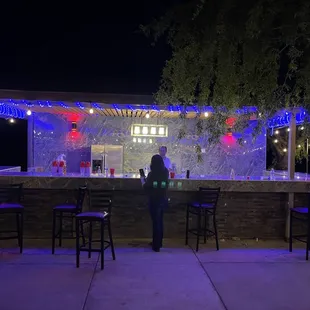 a woman standing in front of a bar