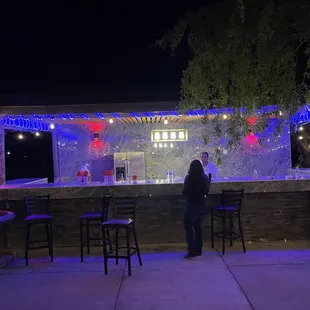 a woman standing in front of a bar