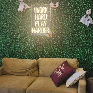 a couch in front of a wall with a sign that says work hard play harder