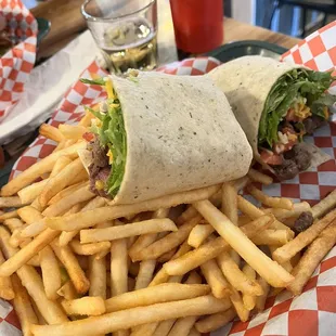 Steak bites with lettuce, tomato and cheese in a garden veggie wrap, bourbon BBQ dipping sauce and fries.