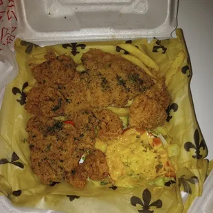 Shrimp and catfish combination plate with fries and a salad.