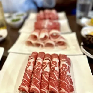 a long table of raw meats