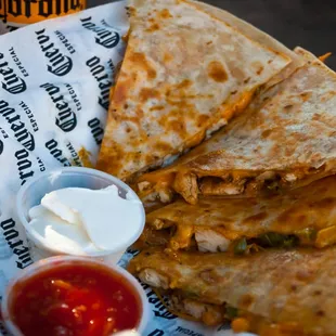 One of our most popular dishes: the grilled chicken quesadilla, featuring spicy peppers, cheddar cheese, fresh salsa, and sour cream.