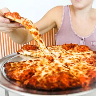 a woman holding a slice of pizza