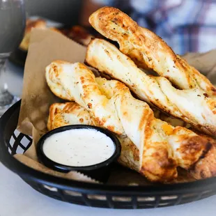 a basket of cheesy breadsticks