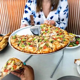a woman holding a slice of pizza