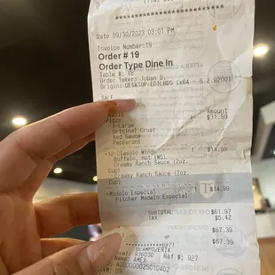 a hand holding a receipt