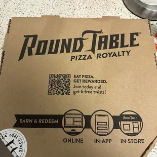 a person holding a pizza box