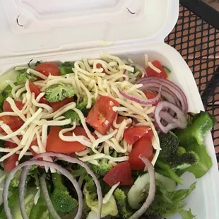 a salad in a styrofoam container