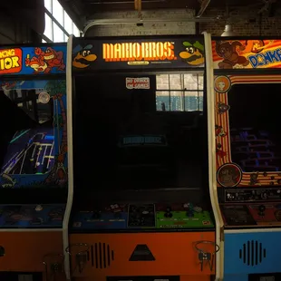 a row of arcade machines in a warehouse