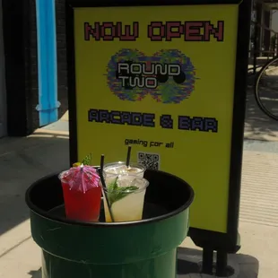 a green trash can with drinks in it