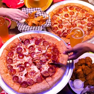 a pizza with pepperoni and chicken wings