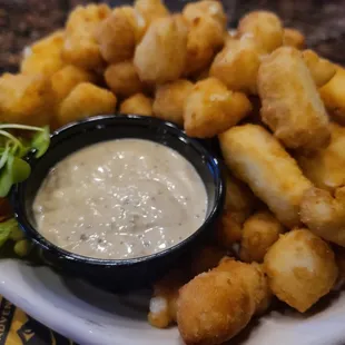 a plate of fried tater tots and a bowl of dip